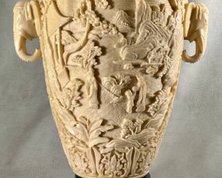 A large vintage Chinese style carved resin ivory colored vase with elephant head handles, on a carved base