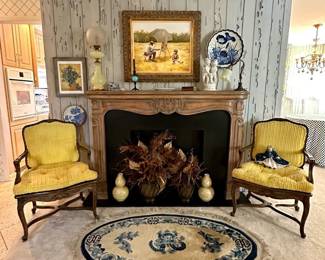 Pair of vintage French Louis XV style armchairs w/gold color fabric upholstery, a vintage Chinese design oval blue and cream color rug with dragon motifs, a fantastic large opaline uranium glass oil lamp, an antique goose neck table lamp with uranium glass ruffled shade, a large bisque porcelain figural statue of two children at grape harvest, a pair of Chinese double gourd vases in yellow glaze with raised white applied design of birds in flowering branches, resting on carved wooden stands; a vintage carved wood fireplace mantel and surround