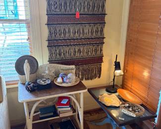 Ethnic wall hanging.  Little wicker desk.  Blue painted coffee table glass top.