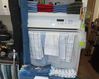 Piles of brand new tea towels, new in box CuisinArt waffle maker.