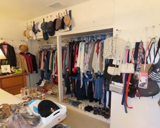 Closets of ladies clothing, purses, hats and shoes.