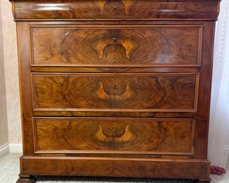 19th-century French Louis Philippe walnut commode featuring exquisite bookmatched burl walnut veneer and elegant restrained lines typical of the period. Celebrated for highlighting natural wood beauty, this classic antique offers generous storage and timeless European sophistication for bedroom or formal interiors.