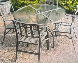 Cast aluminum outdoor table and chair set has burnished bronze finish, 48" diameter inset glass top table, 4 arm chairs and 2 side chairs