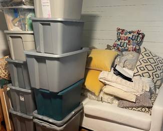 bins of mens and womens clothing, blankets, throw pillows