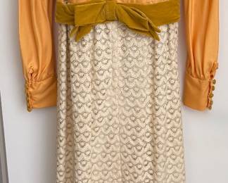 Vintage 1970s formal maxi dress Golden satin bodice with velvet sash Full lace skirt. Back view.