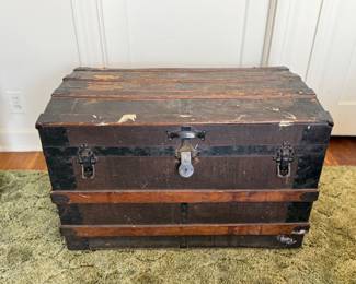 Rustic vintage wooden and metal steamer trunk. Hinges work. On small wheels. Lined with cedar like contact paper. Measures: 32" wide x 21" tall x 18" deep.