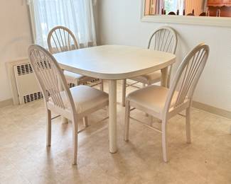 Modern white formica dining table with four matching chairs. Table measures 42“ x 42“ and is 29 inches tall.
