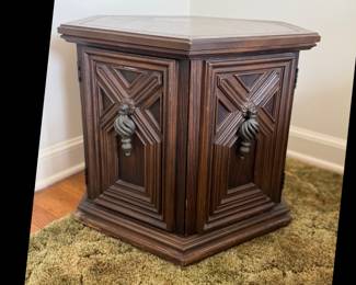 70's hexagon end table. Dark wood with two front swinging doors. Top is attached but would benefit from some reinforcement from inside. Measures: 24" wide x 21" tall. Some scuffing on corners, over all nice piece.