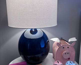 Navy blue ceramic table lamp, eyeglasses, piggy bank, round nightstand