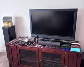 Dark wood media console with glass doors, flat screen TV, AV equipment