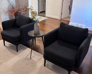 Pair of modern black accent chairs with round coffee table