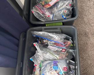 Bins of LEGO sets in bags with instruction manuals