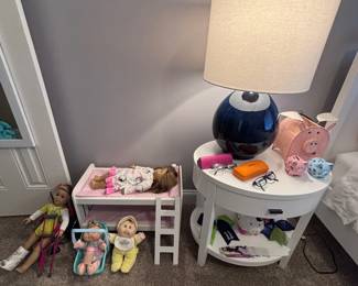 Navy blue globe table lamp, white cubby shelf with dolls and plush toys