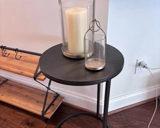 Round black metal accent table with glass hurricane candle holder