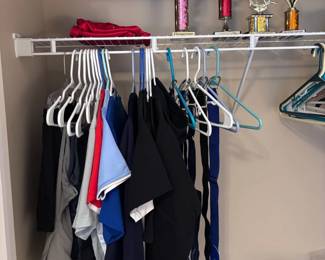 Closet of kids clothing, trophies, handbags