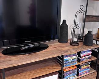 Flat screen TV on wood console, DVD collection, decorative lantern
