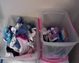 Bins of American Girl doll clothes and accessories