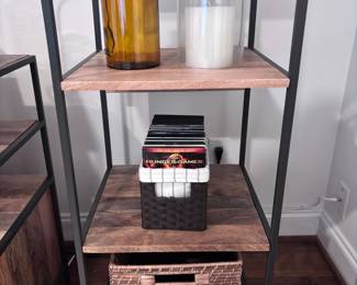 Industrial shelf detail with amber glass bottle, candles, woven basket