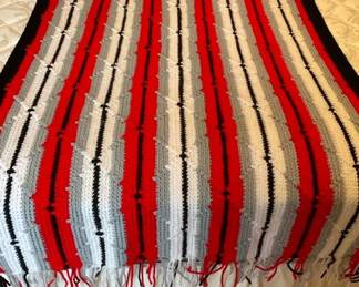handmade crochet afghan throw blanket featuring a striped pattern in red, black, white, and gray col