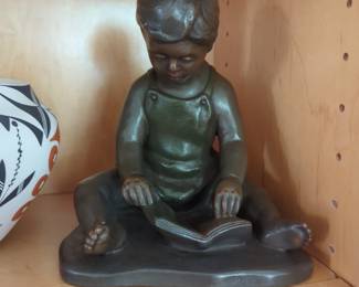 vintage 1976 figurine is a reproduction of the "Boy Reading a Book" sculpture by artist John Terken