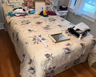 Bed with headboard, decorative pillows and miscellaneous clothin