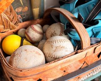 Vintage baseballs in wicker basket, sports memorabilia