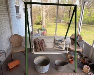 Metal porch swing frame, wicker chairs, galvanized buckets, patio decor