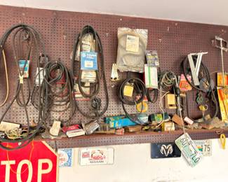 Pegboard with extension cords, belts, hardware, vintage license plates