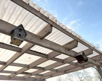 Wooden pergola with decorative birdhouses