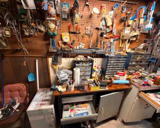 Full workshop pegboard wall with hand tools, workbench