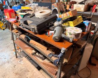 Workbench with hardware, tools, tins, and garage supplies