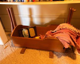Antique wooden cradle, vintage textiles, walking canes