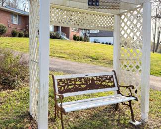 White wooden garden arbor with lattice and bench