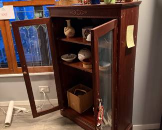 vintage dark-stained wood curio cabinet, perfect for displaying your prized collectibles. This hutch features glass-paneled double doors with metal hardware, offering a clear view of its three interior shelves. $380