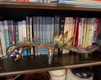 Oaxacan Dragon Alebrije: A long, hand-painted Mexican folk art sculpture featuring a green and brown serpent-like body Price: $195.00 |  Vintage Chinese Language Hardcover Collection: A set of approximately 14 uniform grey-bound volumes with blue spine labels, featuring classical Chinese titles and red stamps. Price: $120.00 (Set) | Assorted Books 
