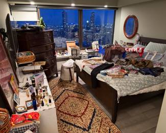 Bed Frame: This is a dark wood slatted platform bed Queen size, $300, Mirror: Cherry wood mirror hanging above the bed is a round wood, with a thick, reddish-brown frame $250 multiple available. Dresser: The large, dark-finished chest is a bow-front dresser, a traditional design known for its curved drawer fronts, high quality wood, $700, Traditional Persian-style runner featuring a dense floral medallion pattern in red, ivory, and dark blue $400 