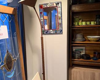 Decorative floor lamp featuring a slender, curved body and a conical shade $210 