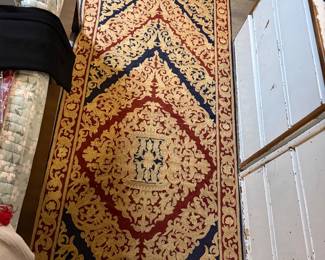 Traditional Persian-style runner featuring a dense floral medallion pattern in red, ivory, and dark blue $400 