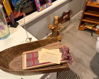 large, hand-carved "boat-shaped" vessel with a distinctive curved handle. Likely used historically for dough or grain, it shows a rustic patina and includes internal items like vintage papers. $60
