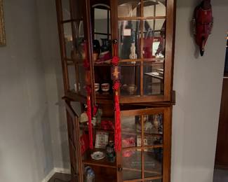 Wooden corner curio display cabinet, designed to showcase collectibles and decorative items $995