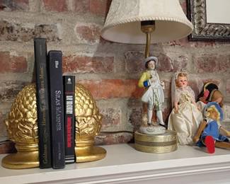 Fireplace mantel decor, porcelain figurines, gold pineapple bookends, table lamp, framed art