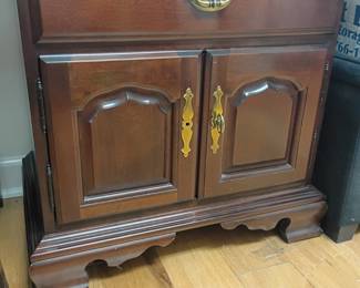 Dark wood nightstand cabinet, brass hardware, carved panel doors, vintage end table