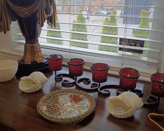 Red glass votives, decorative plates, gold figurine lamp, table decor