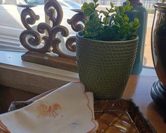 Ornate scrollwork candlestick holder, green textured planter pot, embroidered linens napkins, decorative home accents lot