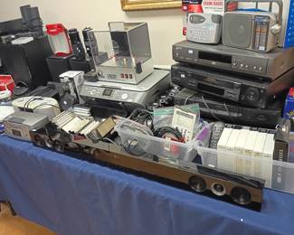 Electronics lot, VCR players speakers stereo equipment, VHS tapes, vintage audio video components, household electronics assortment