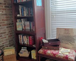 Corner bookshelf cabinet with books, side table, floral cushion, wicker basket, reading nook