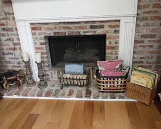 Brick fireplace with white mantel, fireplace tools, candle holders, iron grate, hearth decor
