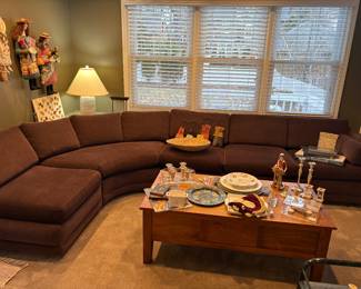 Curved low-profile secional with 2 ottomans, pottery lamp, coffee table shown with Judica items