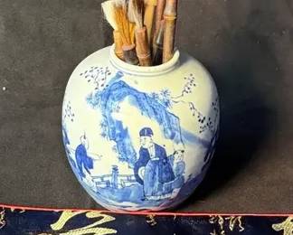 Chinese porcelain jar containing a collection of calligraphy brushes.