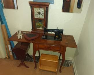 Old singer sewing machine with table and clock accessory.
